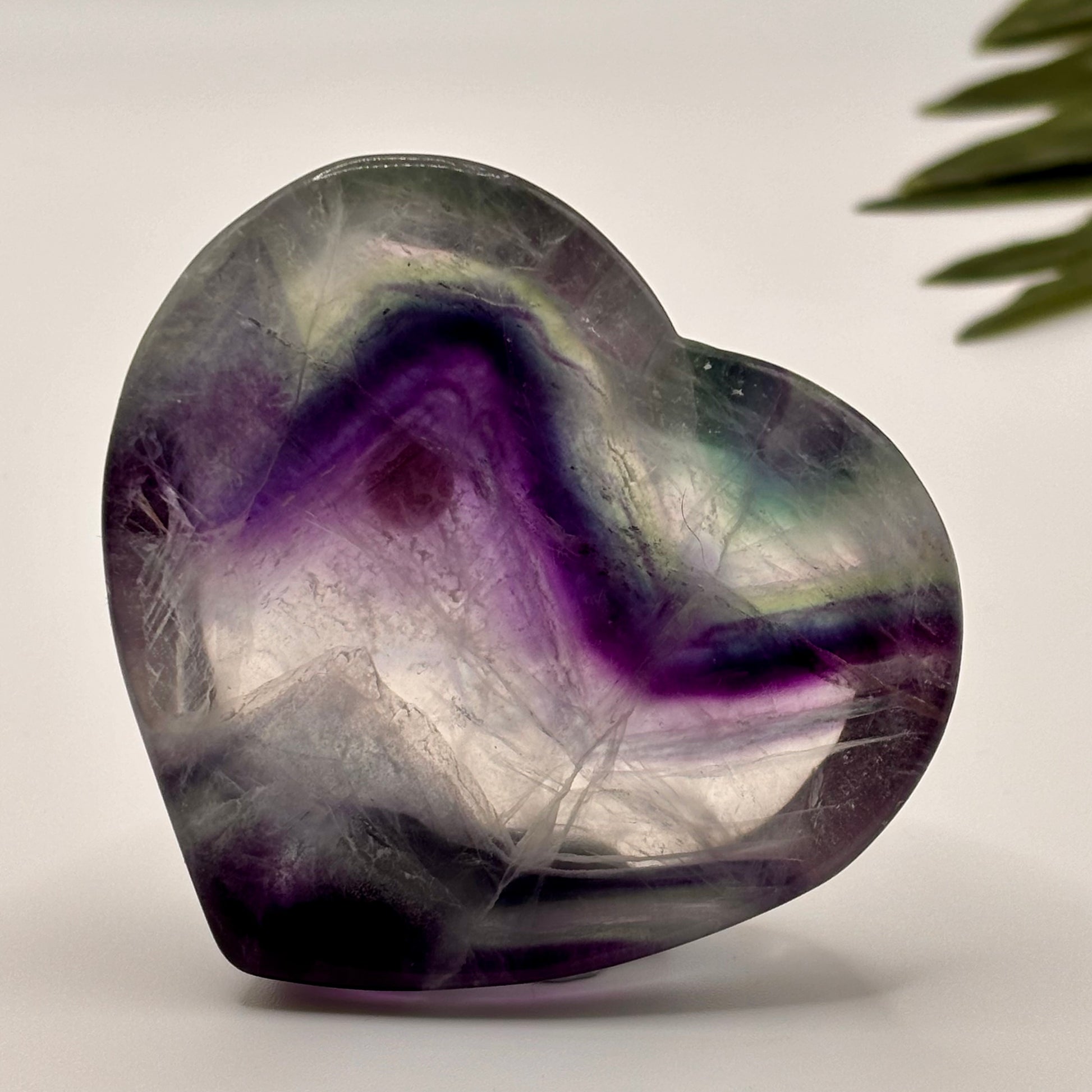 Heart-shaped crystal with purple and gray colors on a light background