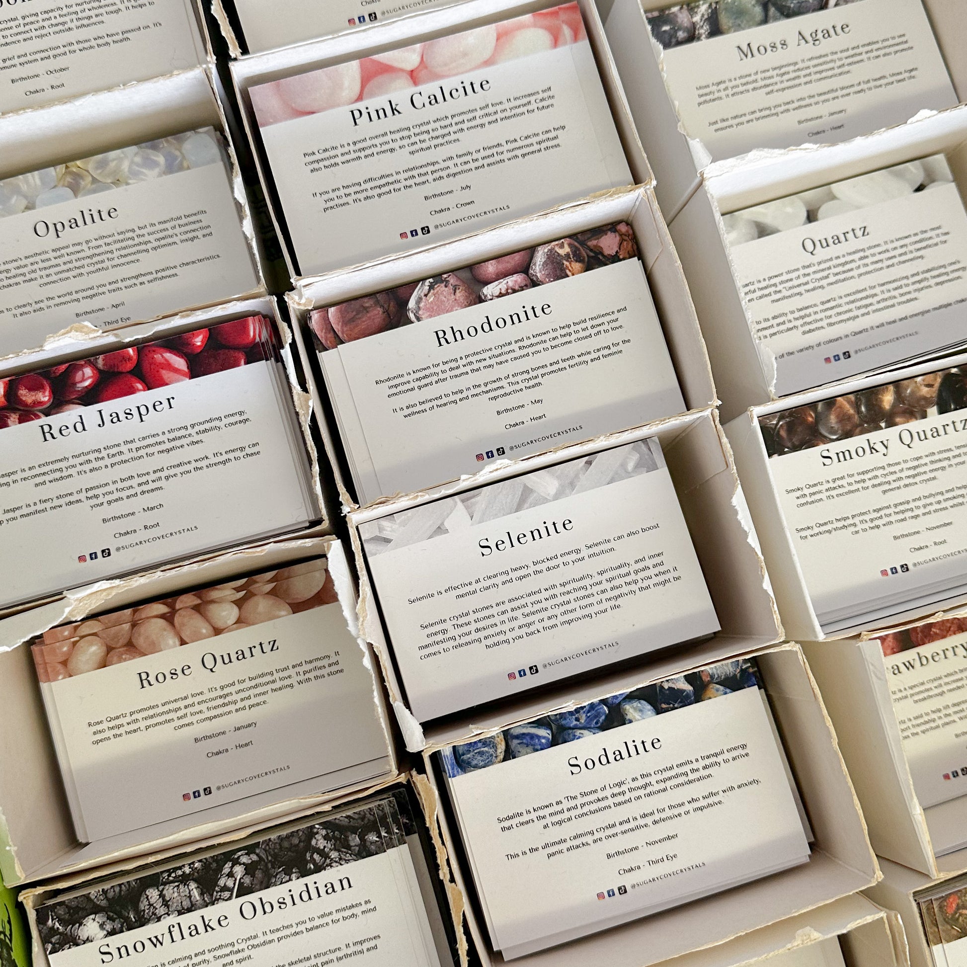 A collection of Crystal information cards in a grid layout, each card featuring a different crystal and its name, with a white and beige color scheme.