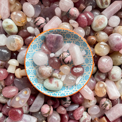 a lovely collection of pink crystals, including rose quartz, rhodonite, flower agate, strawberry quartz in a little bowl